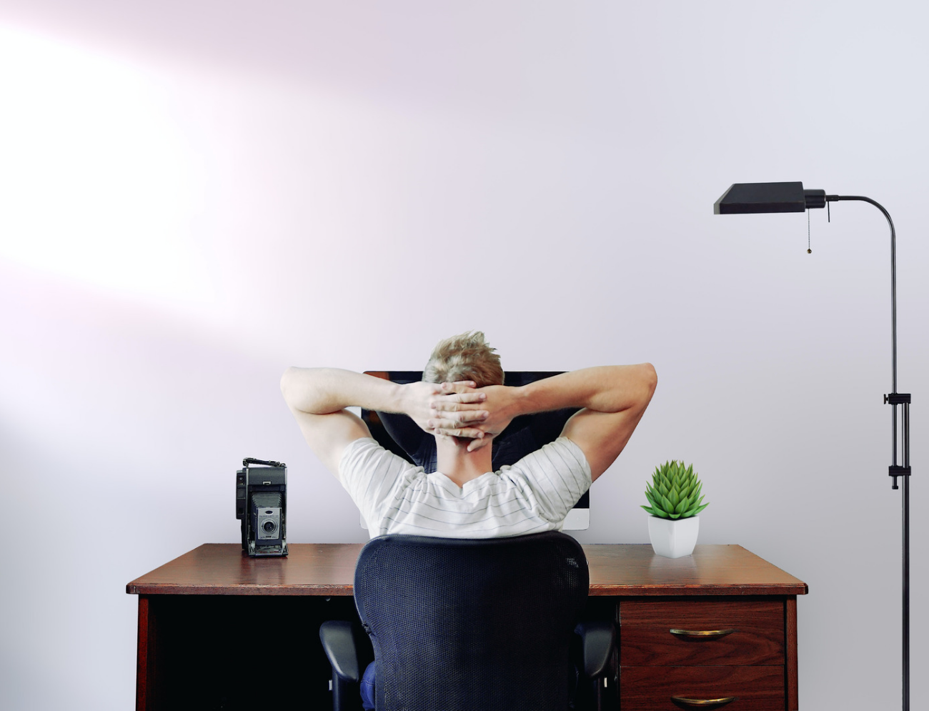guy relaxing at a desk. view from behind
